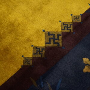 Plush rug detail showing deep yellow, maroon, and navy blocks with geometric and floral patterns.