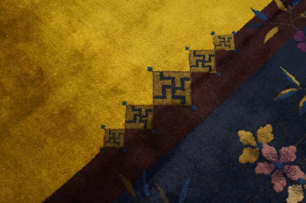 Plush rug detail showing deep yellow, maroon, and navy blocks with geometric and floral patterns.