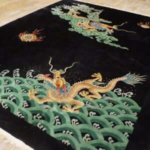 Black high-pile rug featuring gold dragons, green waves, and clouds on distressed wood flooring.