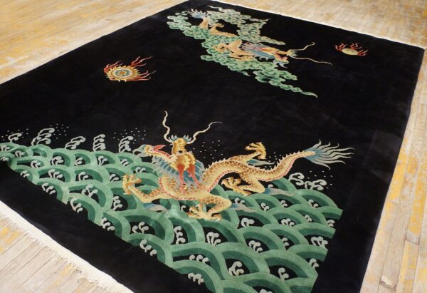 Black high-pile rug featuring gold dragons, green waves, and clouds on distressed wood flooring.
