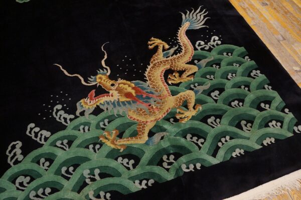 Plush black rug with a golden dragon design above green waves, resting on exposed wood floor.