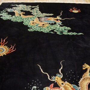 Plush black rug with yellow dragons, pale green clouds, and fiery accents on light wooden floor.
