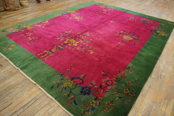 Plush magenta and green rug with scattered colorful floral motifs rests on light wood plank flooring.