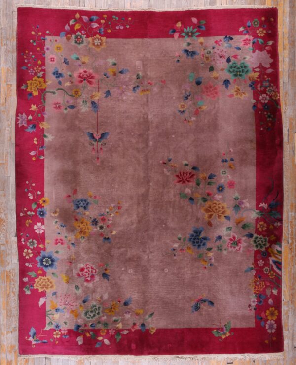Mauve rug with scattered multi-colored flowers and a wide magenta border on wood flooring.