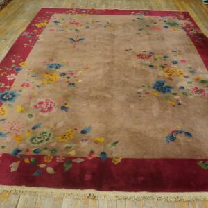 Beige and red floral rug featuring yellow, blue, and pink flowers on a distressed wood floor.
