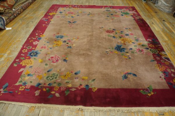 Beige and red floral rug featuring yellow, blue, and pink flowers on a distressed wood floor.