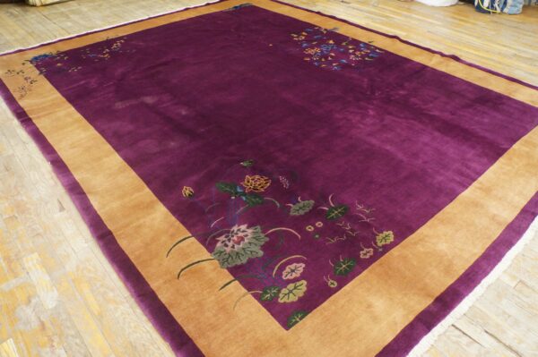 Deep purple high-pile rug featuring a wide tan border and colorful stylized floral corner designs on hardwood.
