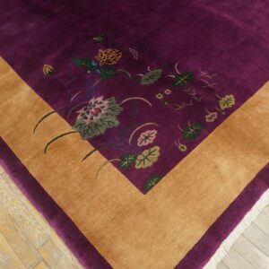 Purple high-pile rug with a gold border and colorful botanical motifs on distressed wood floors.