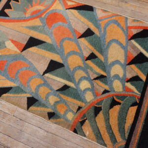 Geometric Art Deco rug featuring orange, teal, gold, and black patterns rests on rustic wooden floor planks.