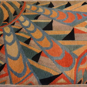 Geometric abstract rug on wood flooring with teal, rust, gold, and black colors and a wide black border.