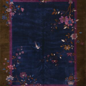 Deep blue high-pile rug with a detailed floral and bird pattern and a wide brown outer border.