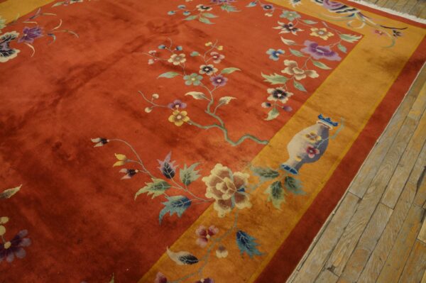 Orange high-pile rug with a detailed floral pattern, wide gold border, visible on weathered wooden floors.