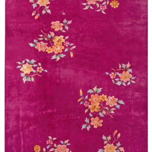 High-pile magenta rug with scattered clusters of multi-colored floral designs and a subtle carved background pattern.