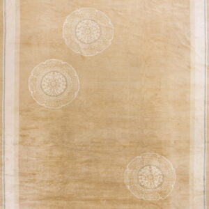 Tan low-pile rug featuring three subtle off-white circular medallions and a multi-layered light-colored border.
