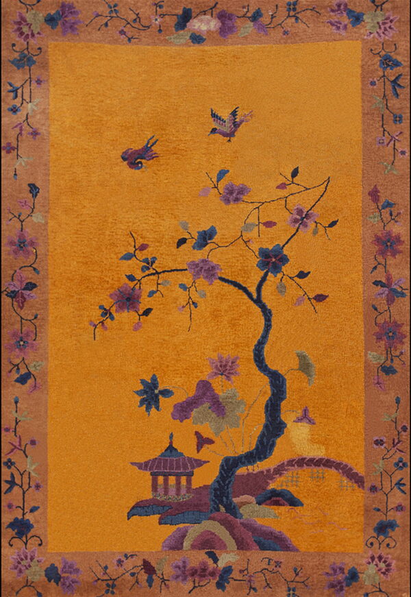 High-pile orange rug depicting a flowering tree, pagoda, and birds within a tan floral border.