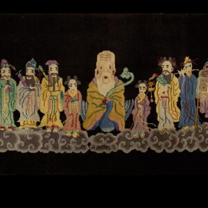 Black pile rug featuring a detailed, colorful tableau of stylized figures above swirling gray clouds.