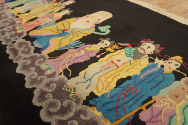 A dark-piled rug featuring a multicolor pattern of stylized human figures floating on carved gray clouds.
