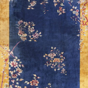 Blue field rug with decorative floral vine patterns and a highly contrasted wide gold border.