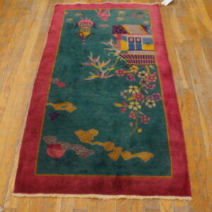Teal runner rug with a magenta border featuring a pictorial scene of a building and blossoms on wood flooring.