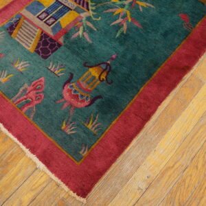 Teal rug featuring pink and yellow figural patterns, a wide magenta border, set on light wood flooring.