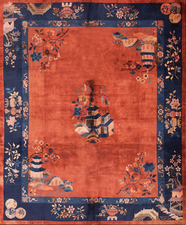 Rust-colored rug with a central pagoda scene bordered by detailed navy blue floral and architectural motifs.