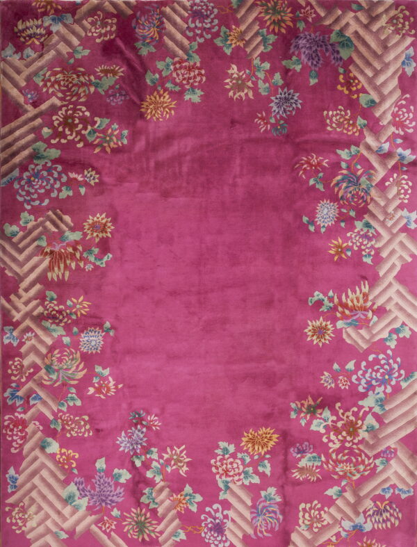 Fuchsia pink rug with colorful floral motifs trailing over a light geometric basketweave border.