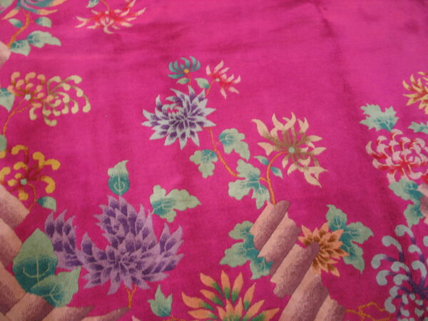 Magenta rug with intricate floral designs, including purple, yellow, and teal blooms and foliage.