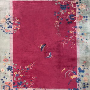 Plush magenta rug with an icy green border and colorful floral and butterfly patterns.
