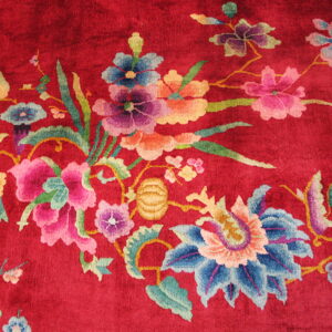 High-pile ruby rug featuring vibrant blue, pink, yellow, and green flowers in a sweeping design.