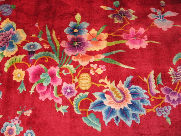 High-pile ruby rug featuring vibrant blue, pink, yellow, and green flowers in a sweeping design.