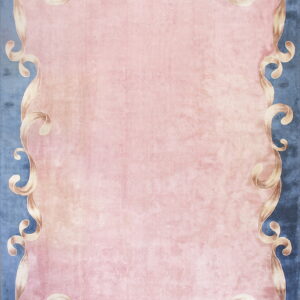 Light pink rug with a ribbon-like beige border framing the center against a textured blue background.
