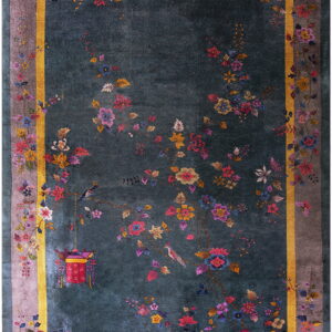 Dark teal rug with colorful floral vines and birds, accented by a bold gold inner border.