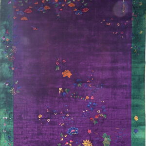 Deep purple rug with scattered floral motifs, multicolored accents, and a wide green border.