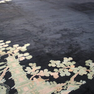 Black plush rug with a detailed Asian-style pattern of a pagoda and trees in muted green and pink.