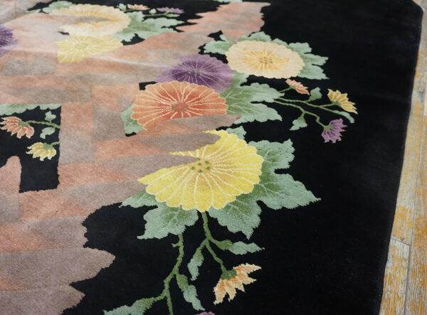 High-pile rug featuring stylized colorful flowers on a black ground with faded rectangular shapes over wood flooring.