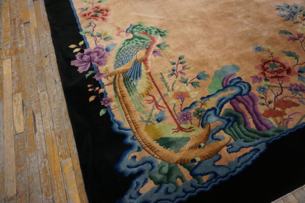 Plush tan rug featuring a carved peacock and flower pattern in blue, purple, and green, beside worn wood planks.