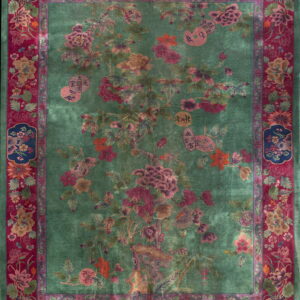 Deep green rug with an ornate central tree pattern and a wide magenta border featuring flowers and vases.