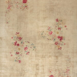 A distressed beige rug features scattered faded pink and blue floral bouquets and a subtle sheen.