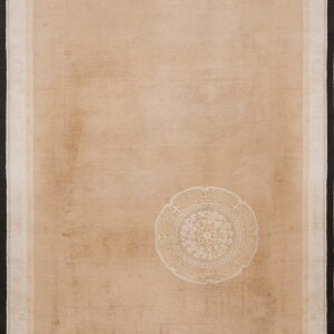 Monochromatic tan rug with a single white decorative medallion and layered light and dark borders.