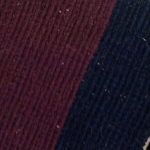 Detail view of a ribbed textile featuring deep maroon and navy blue color blocks.