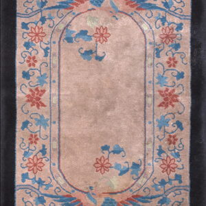 A dusty rose runner rug featuring blue and coral stylized birds and floral designs within a black border.