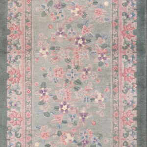 Pale sage runner rug with a central arch field decorated with pink and purple floral blossoms.