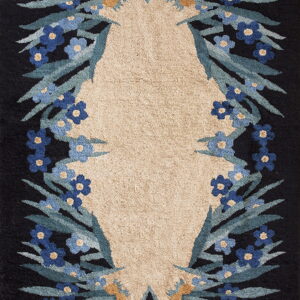 High and low pile rug with a beige center framed by black, blue flowers, and green leaves.