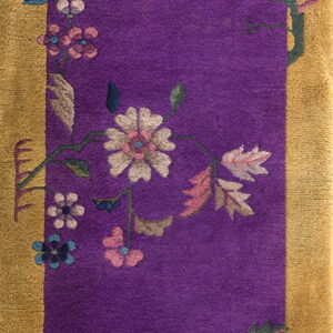 Plush purple rug featuring a wide gold border and stylized pink, white, and blue floral arrangements.