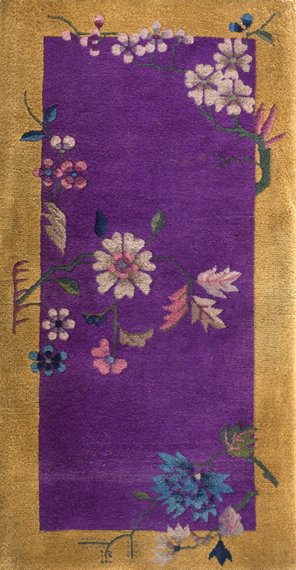 Plush purple rug featuring a wide gold border and stylized pink, white, and blue floral arrangements.