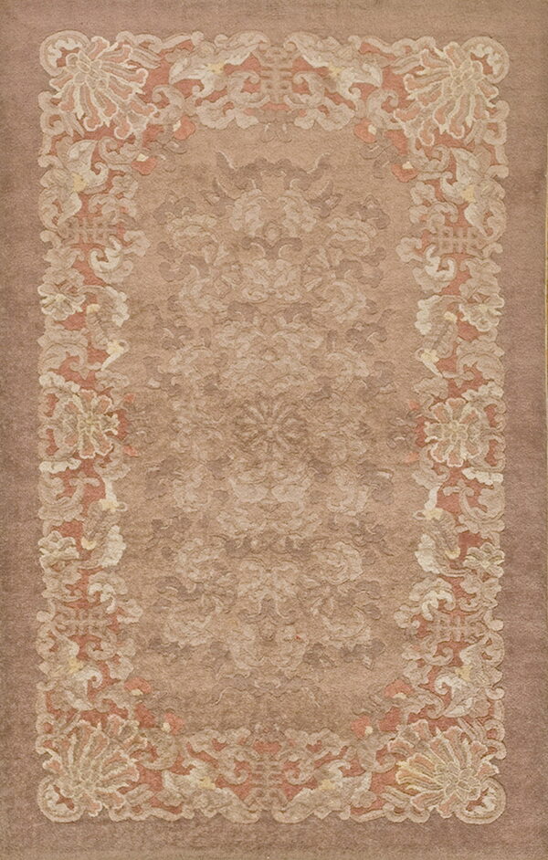 Low-pile rug in brown and tan with a sculpted botanical border and subtle floral field pattern.