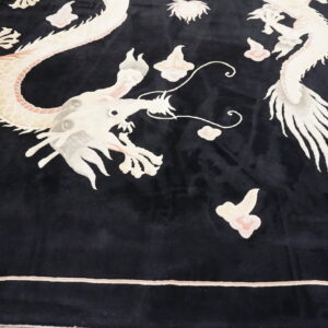 Detailed view of a black rug with large light-colored dragon and cloud motifs.