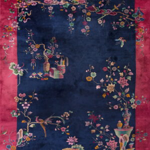 Navy rug with a bold magenta border and colorful intricate designs of birds, flowers, and vases.