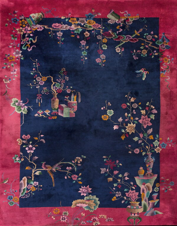 Navy rug with a bold magenta border and colorful intricate designs of birds, flowers, and vases.