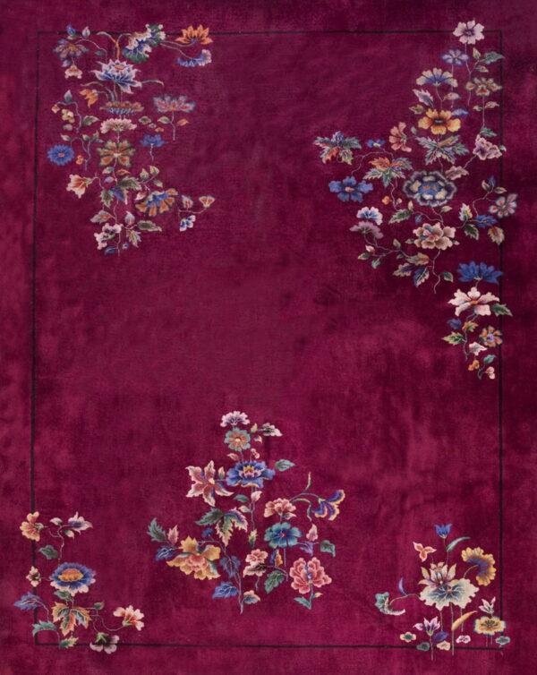 A vibrant, deep red rug featuring scattered blue, yellow, and pink floral patterns framing the central field.